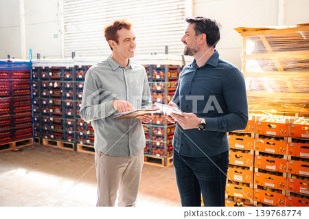 Two managers discussing fruit inventory using a tablet in a warehouse Two managers discussing fruit inventory using a tablet in a warehouse 139768774