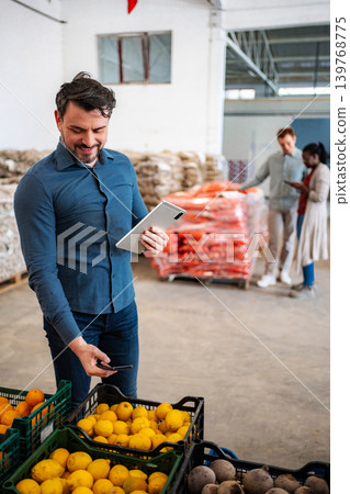 Man scanning produce crates using digital tablet in warehouse 139768775