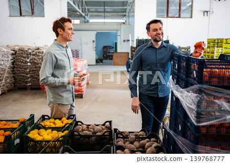 Workers checking produce in a food distribution warehouse 139768777