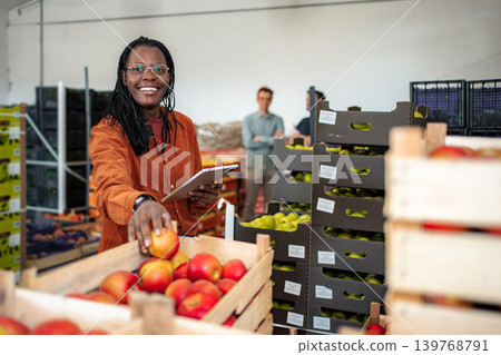 Woman inspecting apples in warehouse using digital tablet Woman inspecting apples in warehouse using digital tablet 139768791