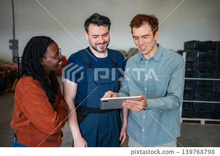Warehouse workers collaborating on digital tablet for logistics management 139768798