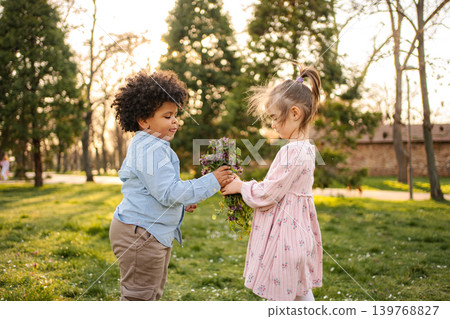 Children sharing flowers in park expressing friendship 139768827