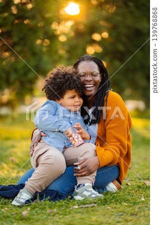 Mother son bonding outdoors enjoying sweet treats Mother son bonding outdoors enjoying sweet treats 139768868