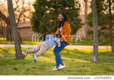 Mother and son playing, laughing, and spinning in park Mother and son playing, laughing, and spinning in park 139768869