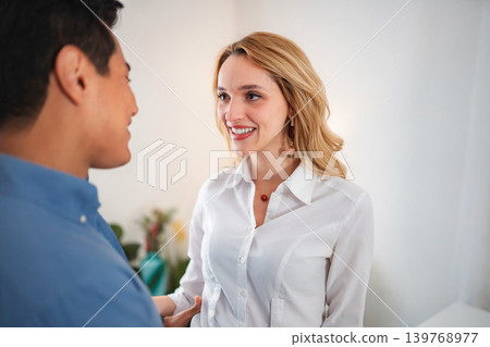 Happy working couple conversing smiling at one another indoors 139768977