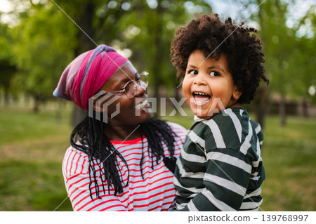 Mother and son enjoying family time outdoors laughing Mother and son enjoying family time outdoors laughing 139768997
