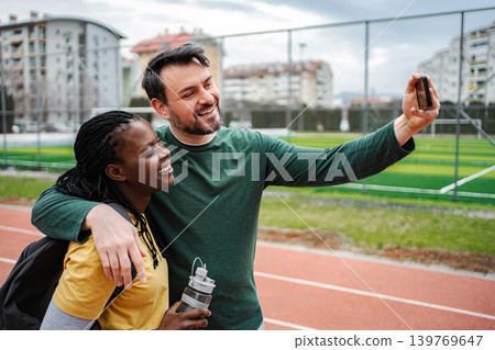 Diverse couple smiling, taking selfie after outdoor workout Diverse couple smiling, taking selfie after outdoor workout 139769647
