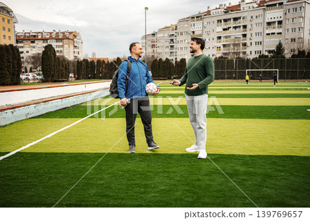 Two friends talking on a football field before game Two friends talking on a football field before game 139769657