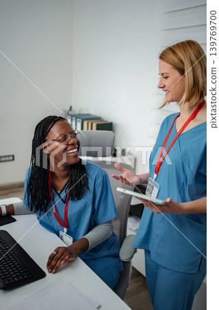 Two nurses discussing patient information using a digital tablet Two nurses discussing patient information using a digital tablet 139769700