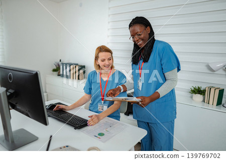 Female nurses collaborating on computer during busy shift 139769702