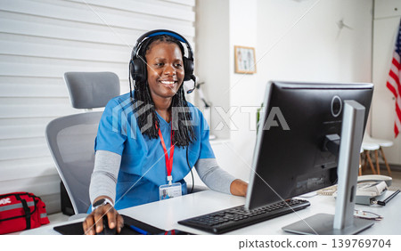 Female nurse working on computer providing remote healthcare services Female nurse working on computer providing remote healthcare services 139769704
