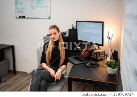 Young adult woman sitting at ergonomic home office desk Young adult woman sitting at ergonomic home office desk 139769724