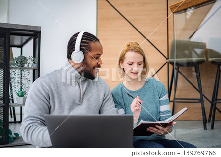 Diverse students collaborating on laptop studying together Diverse students collaborating on laptop studying together 139769766