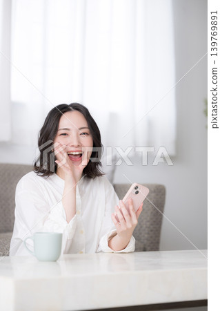 Reviews of women holding smartphones, smiling women, and images of their lifestyle at home, including reviews of social media, apps, and shopping. Reviews of women holding smartphones, smiling women, and images of their lifestyle at home, including reviews of social media, apps, and shopping. 139769891