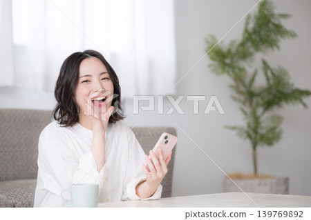 Reviews of women holding smartphones, smiling women, and images of their lifestyle at home, including reviews of social media, apps, and shopping. Reviews of women holding smartphones, smiling women, and images of their lifestyle at home, including reviews of social media, apps, and shopping. 139769892