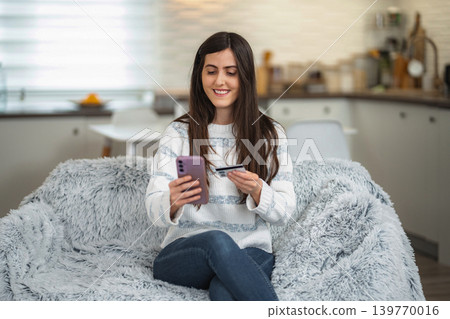Woman shopping online using smartphone and credit card Woman shopping online using smartphone and credit card 139770016