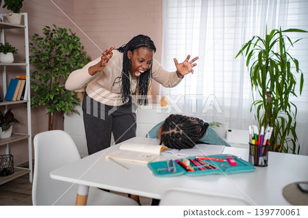 Frustrated mother yelling at stressed daughter doing homework Frustrated mother yelling at stressed daughter doing homework 139770061