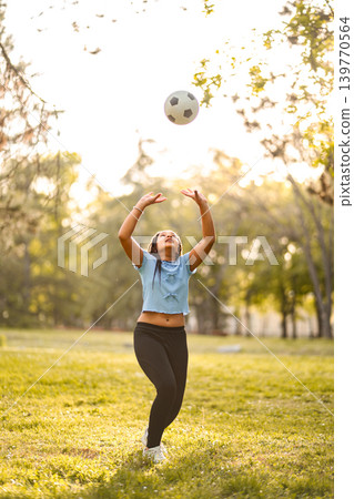Young girl playing with soccer ball in park Young girl playing with soccer ball in park 139770564