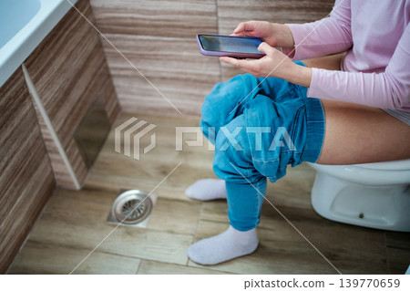 Relaxing moment with a phone in a cozy bathroom setting Relaxing moment with a phone in a cozy bathroom setting 139770659