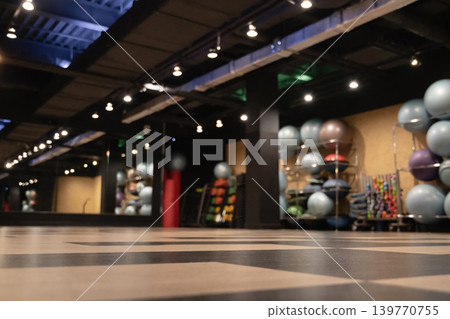 Empty blurred modern fitness studio with workout equipment and dark interior 139770755