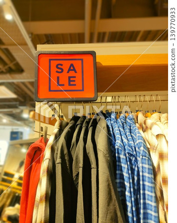 Sales announcement signs and clothing at an apparel shop Sales announcement signs and clothing at an apparel shop 139770933