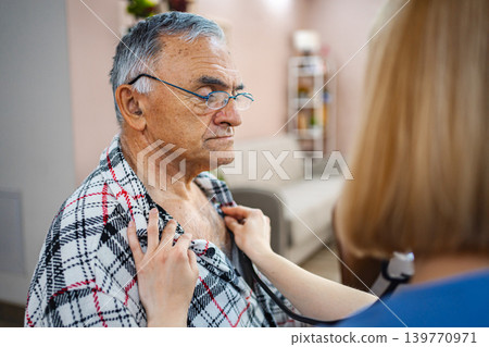 Elderly man receiving medical check-up in cozy setting Elderly man receiving medical check-up in cozy setting 139770971