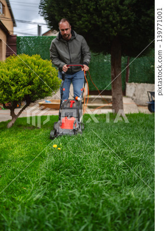 Mowing the lush green lawn on a sunny afternoon in the backyard with a sense of relaxation and tidiness in the air Mowing the lush green lawn on a sunny afternoon in the backyard with a sense of relaxation and tidiness in the air 139771001