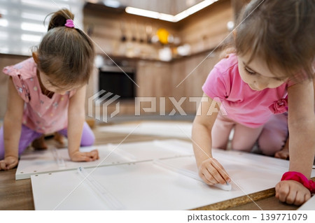 Children creating art in a cozy kitchen during afternoon playtime Children creating art in a cozy kitchen during afternoon playtime 139771079