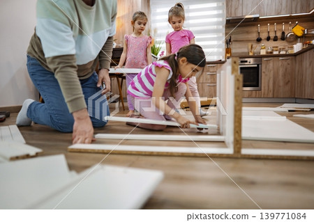 Family builds furniture together in a cozy modern kitchen Family builds furniture together in a cozy modern kitchen 139771084