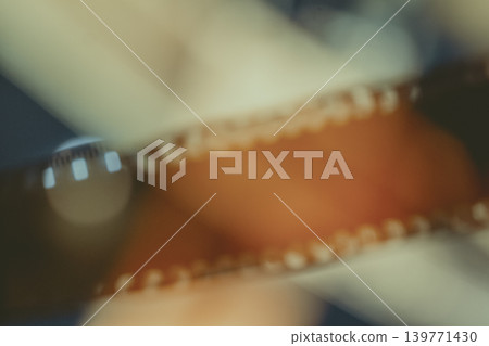 Blurred film strip, abstract cinema background with orange frame, sprocket holes, soft light leaks. Concept of film production, analog photography, movie archive, creative media, memory, storytelling Blurred film strip, abstract cinema background with orange frame, sprocket holes, soft light leaks. Concept of film production, analog photography, movie archive, creative media, memory, storytelling 139771430