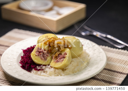 Potato dumplings filled with minced meat, topped with fried onions, served with sauerkraut and red cabbage Potato dumplings filled with minced meat, topped with fried onions, served with sauerkraut and red cabbage 139771450