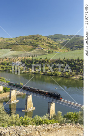 Steam train on railway bridge (Ponte Ferroviaria do Tua), Tua, Alto Douro, Portugal Steam train on railway bridge (Ponte Ferroviaria do Tua), Tua, Alto Douro, Portugal 139771490