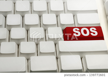 A close-up shot of a white computer keyboard with a single red button labeled SOS, symbolizing a digital distress signal, emergency help, or technical support A close-up shot of a white computer keyboard with a single red button labeled SOS, symbolizing a digital distress signal, emergency help, or technical support 139771601