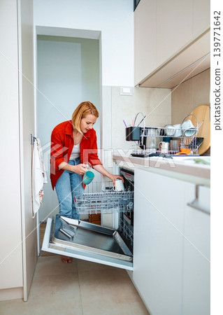 Washing dishes with a cheerful spirit in a modern kitchen Washing dishes with a cheerful spirit in a modern kitchen 139771642