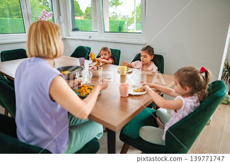 Family enjoying a meal together in a bright setting 139771747