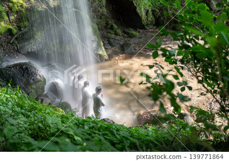 A scene of a waterfall ascetic practice, with the awe-inspiring power of the waterfall conveyed through the white robes. A scene of a waterfall ascetic practice, with the awe-inspiring power of the waterfall conveyed through the white robes. 139771864
