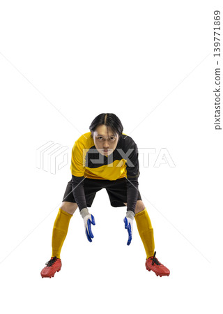 A young Indonesian southeast asian male soccer goalkeeper in a yellow and black uniform with gloves and red cleats, standing in a ready stance isolated on a white background A young Indonesian southeast asian male soccer goalkeeper in a yellow and black uniform with gloves and red cleats, standing in a ready stance isolated on a white background 139771869