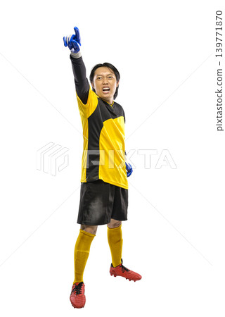 Indonesian southeast asian soccer goalkeeper in yellow and black jersey celebrating victory with raised arm and finger pointing up, shouting with joy, isolated on white background Indonesian southeast asian soccer goalkeeper in yellow and black jersey celebrating victory with raised arm and finger pointing up, shouting with joy, isolated on white background 139771870