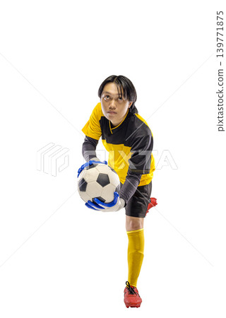 A young Indonesian southeast asian male soccer goalkeeper in a yellow and black uniform holds a soccer ball with gloves, looking up with focus, isolated on a white background A young Indonesian southeast asian male soccer goalkeeper in a yellow and black uniform holds a soccer ball with gloves, looking up with focus, isolated on a white background 139771875