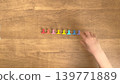 一雙稚嫩的小手正在擺弄八個色彩鮮豔的小夾子。 139771889