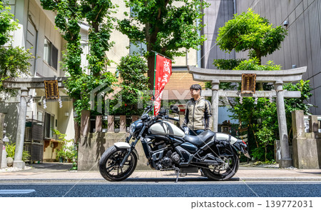 A male motorcyclist looking at his smartphone in front of Sanuki Kobai Inari Shrine. A male motorcyclist looking at his smartphone in front of Sanuki Kobai Inari Shrine. 139772031