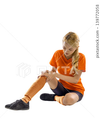 A Indonesian southeast asian female athlete in orange sportswear sitting on the floor, holding her injured knee in pain. Isolated on white background, highlighting sports injuries and muscle strain A Indonesian southeast asian female athlete in orange sportswear sitting on the floor, holding her injured knee in pain. Isolated on white background, highlighting sports injuries and muscle strain 139772058