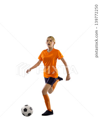 Young Indonesian southeast asian woman in an orange jersey dribbles a soccer ball against a white background. Full length studio shot capturing athletic action, skill, and determination in sports Young Indonesian southeast asian woman in an orange jersey dribbles a soccer ball against a white background. Full length studio shot capturing athletic action, skill, and determination in sports 139772250