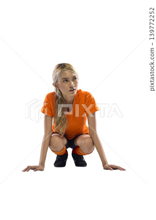 A young Indonesian southeast asian athletic woman wearing a bright orange t-shirt and black shorts squats on the floor during a fitness workout, isolated on a white background A young Indonesian southeast asian athletic woman wearing a bright orange t-shirt and black shorts squats on the floor during a fitness workout, isolated on a white background 139772252