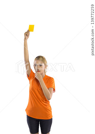 A serious Indonesian southeast asian female sports official in an orange shirt holds up a yellow card and blows a whistle to signal a foul, isolated on a white background A serious Indonesian southeast asian female sports official in an orange shirt holds up a yellow card and blows a whistle to signal a foul, isolated on a white background 139772259