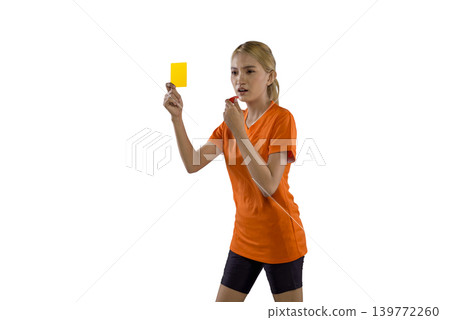 A serious Indonesian southeast asian female sports official in an orange shirt holds up a yellow card and blows a whistle to signal a foul, isolated on a white background 139772260