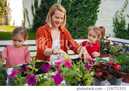 Mother and daughters enjoy spring gardening together Mother and daughters enjoy spring gardening together 139772355