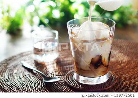 Summer iced café au lait - pour milk into iced coffee Summer iced café au lait - pour milk into iced coffee 139772501