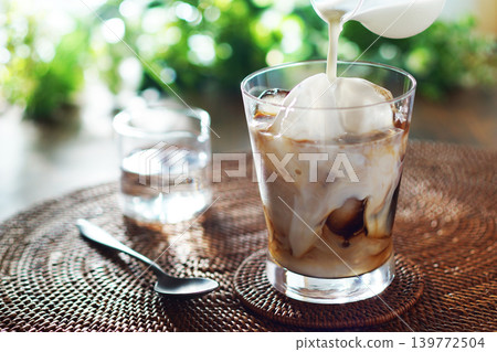 Summer iced café au lait - pour milk into iced coffee Summer iced café au lait - pour milk into iced coffee 139772504