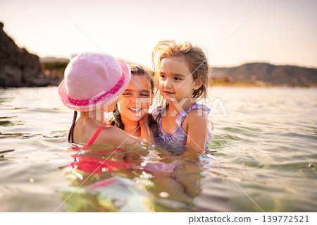 Three happy children swimming and enjoying water during a summer holiday in Greece Three happy children swimming and enjoying water during a summer holiday in Greece 139772521